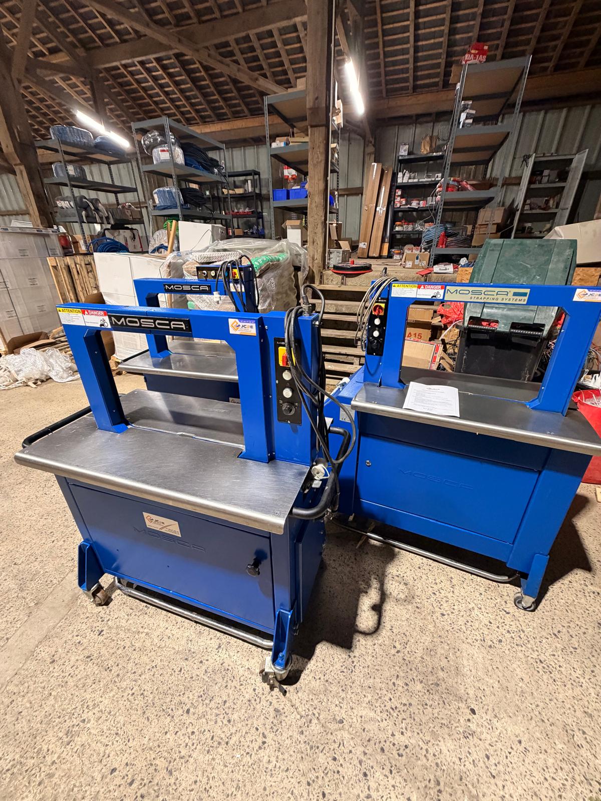 Machines d'emballage bleues Mosca dans un atelier industriel avec etageres